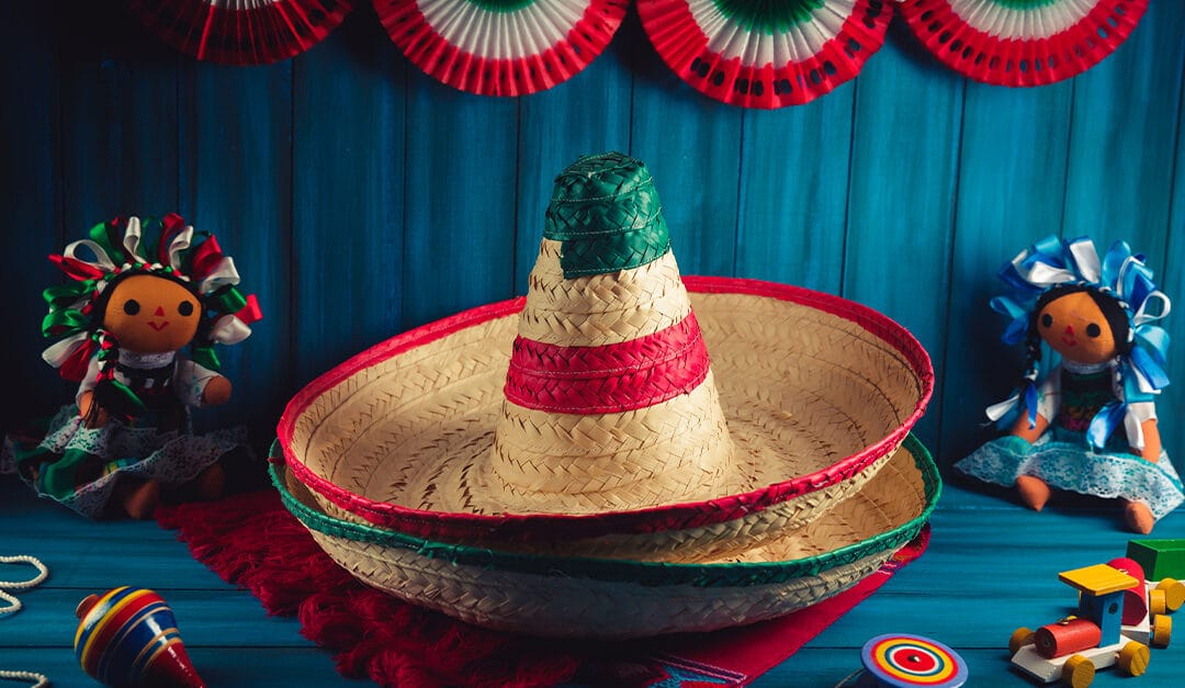 Mexican hats on a serape and toys on a wooden background
