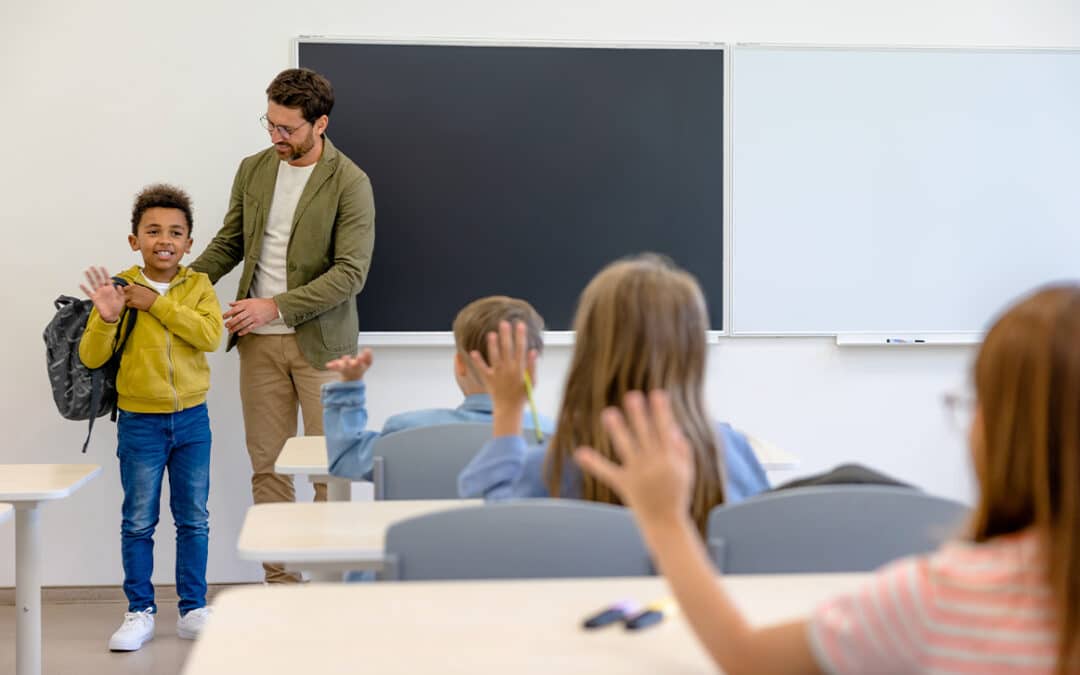 Teacher introducing a new boy to the classmates