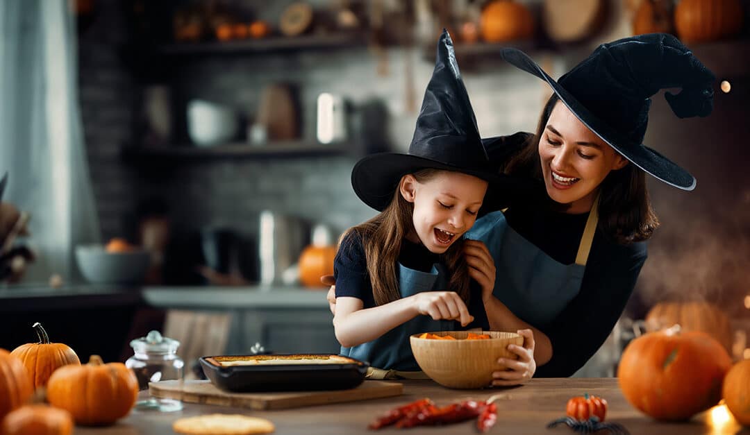 Mother and her daughter having fun at home preparing for Halloween