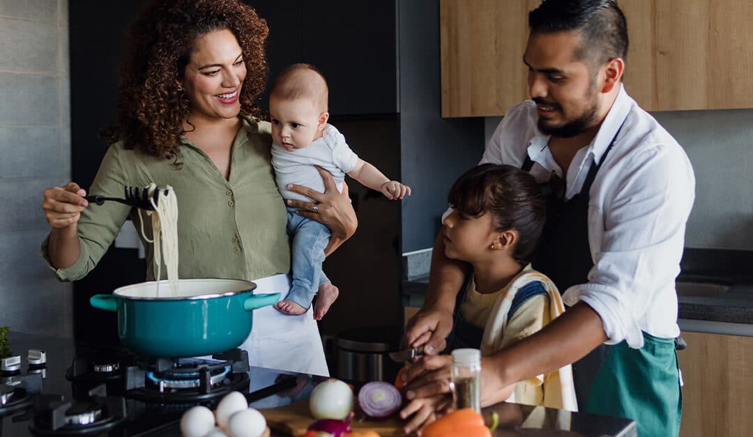 Latin family cooking together with their children in the kitchen at home, speaking their native language of Spanish