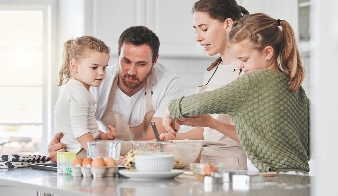 Mom, dad and kids in kitchen baking together for learning Spanish as a family