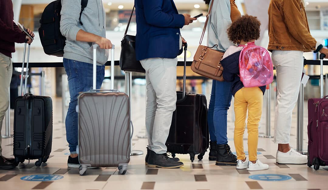 Airport queue, showing the legs of adults and a small child with luggage, waiting for international travel with kids