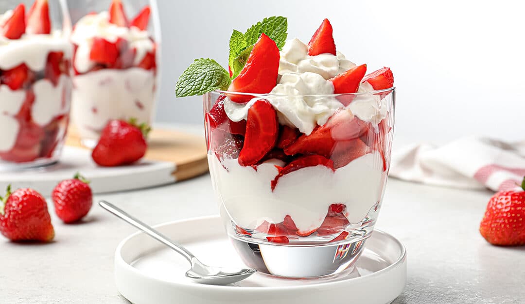 Delicious strawberries with whipped cream served on light grey table, illustrating the blog topic Spanish Recipe: Strawberries and Cream (fresas con crema)