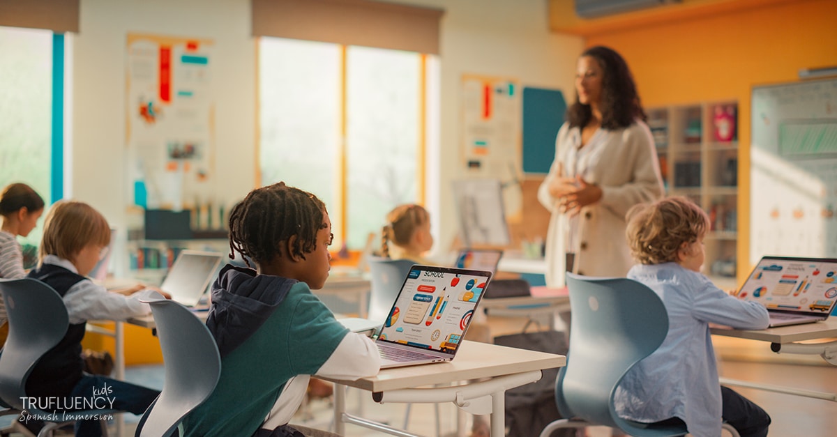 Kids in a classroom learning online with laptops.